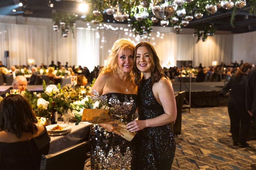 Rachel Ray (R), TWCA’s Director of Development, presenting thank you flowers to 2024 Auction & Gala Chair Amanda Gaige (L)